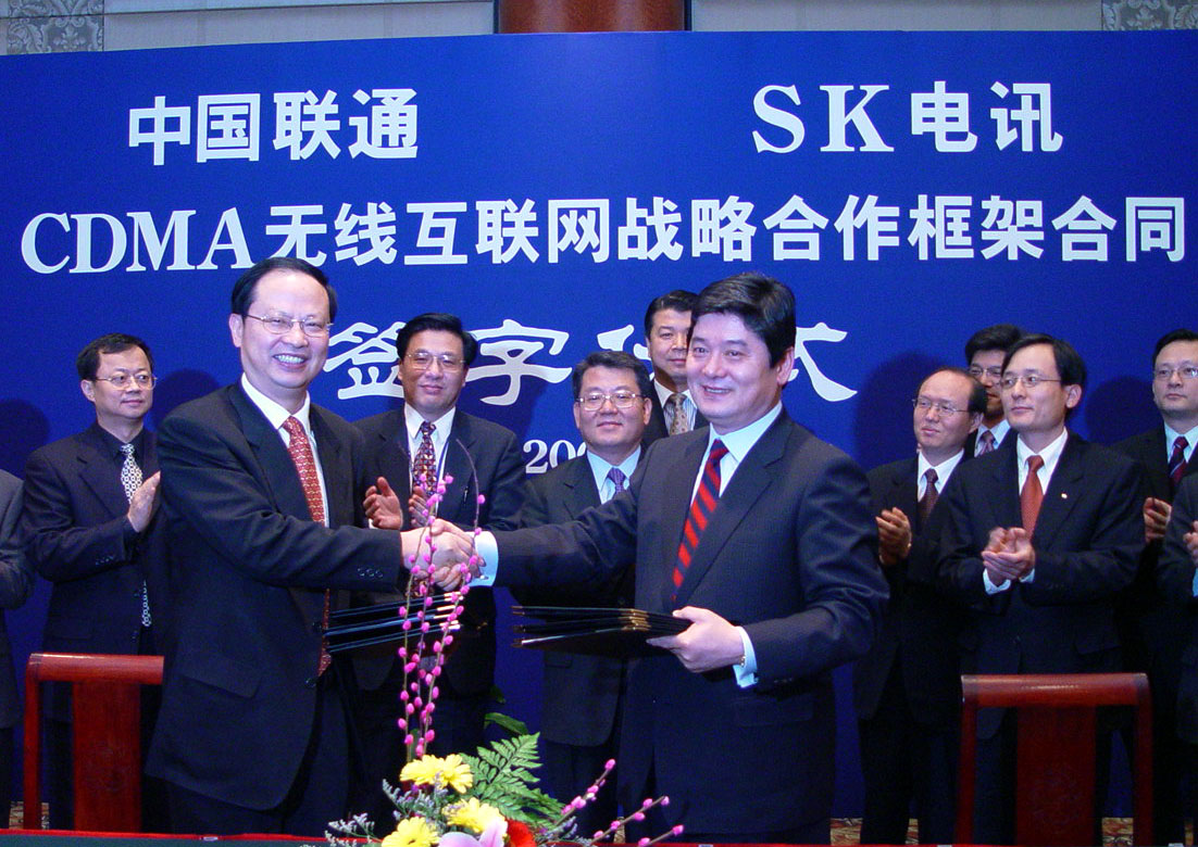Moon Soo Pyo, president of SK Telecom (on right), and Wang Jian Zhou, president of China Unicom (on left), are shown signing the overall contract regarding the establishment of the J/V company in the International Hotel of Beijing on January 16th, 2002.